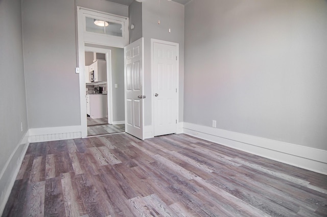 unfurnished bedroom with a high ceiling and light hardwood / wood-style flooring