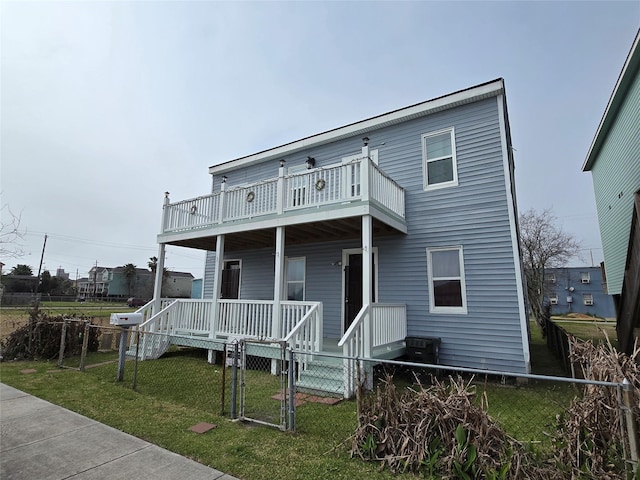 view of front facade featuring covered porch, fence, a front yard, and a gate