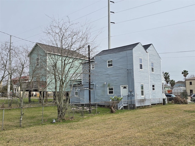 rear view of property with a lawn and fence