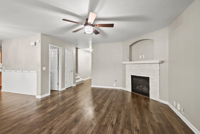 unfurnished living room featuring ceiling fan, dark hardwood / wood-style flooring, and a fireplace