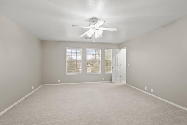 carpeted spare room featuring ceiling fan