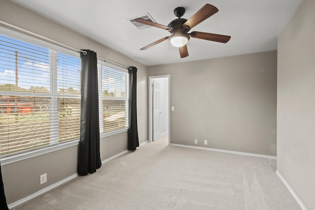 empty room with ceiling fan and light carpet