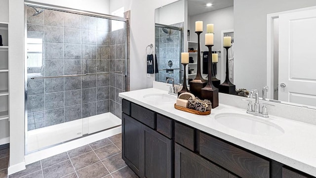 bathroom with a stall shower, tile patterned floors, a sink, and double vanity