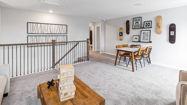 sitting room with carpet floors, baseboards, and an upstairs landing