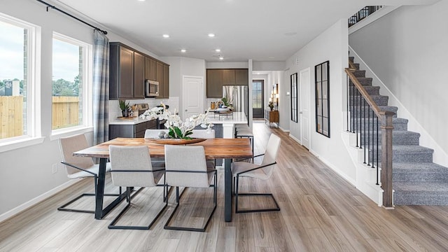 dining space with stairs, light wood finished floors, baseboards, and recessed lighting