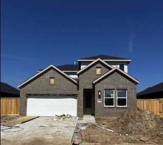 view of front facade with fence, driveway, and an attached garage