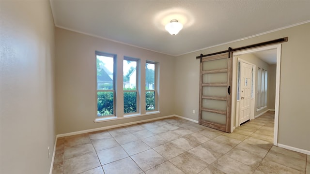 empty room with ornamental molding and a barn door