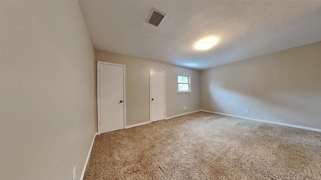 carpeted spare room featuring a textured ceiling