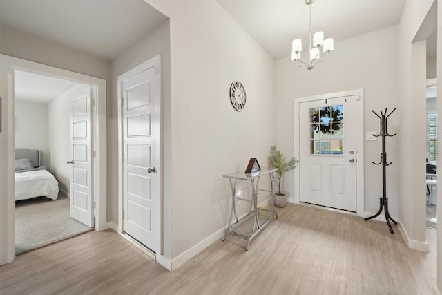 foyer entrance featuring an inviting chandelier and light hardwood / wood-style floors