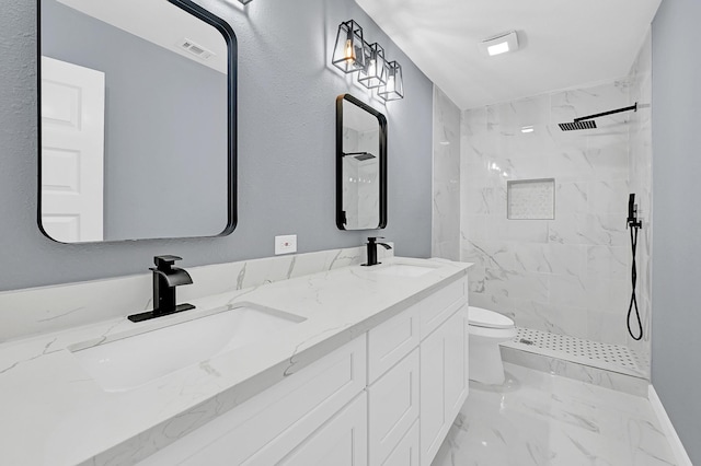 bathroom featuring toilet, vanity, and tiled shower