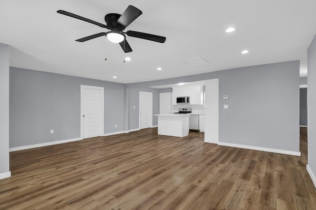 unfurnished living room featuring ceiling fan and dark hardwood / wood-style floors