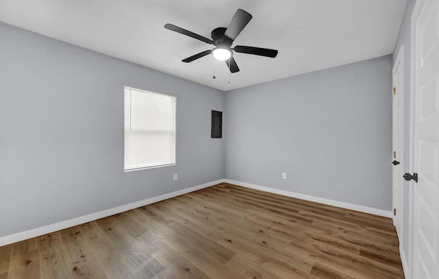 spare room featuring ceiling fan, hardwood / wood-style floors, and electric panel