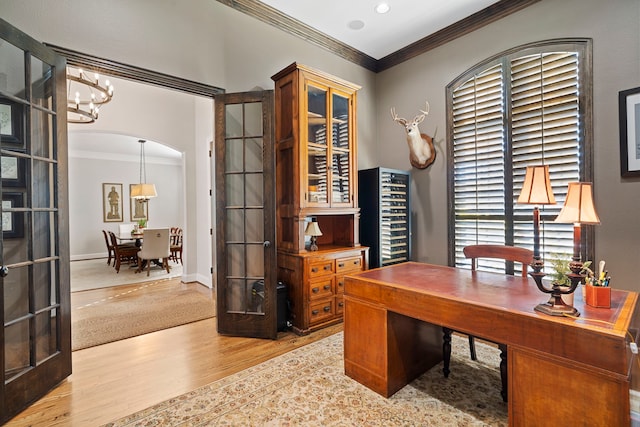 office area with a notable chandelier, ornamental molding, french doors, and light wood-type flooring