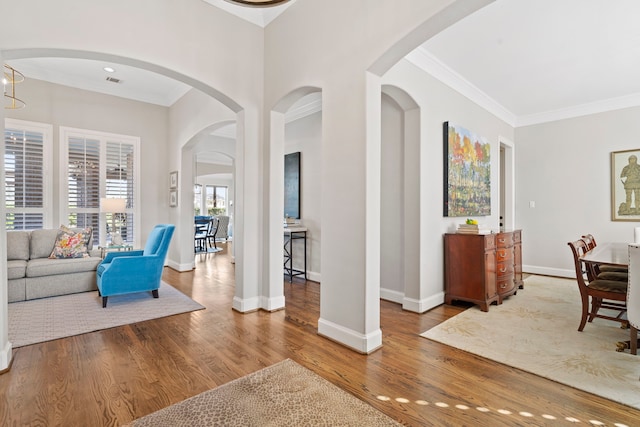 interior space with ornamental molding and hardwood / wood-style floors