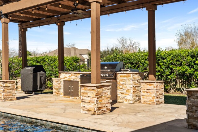 view of patio featuring a pergola, area for grilling, exterior kitchen, and an outdoor bar