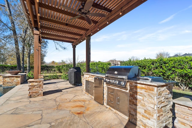 view of patio / terrace featuring ceiling fan, exterior kitchen, and a grill