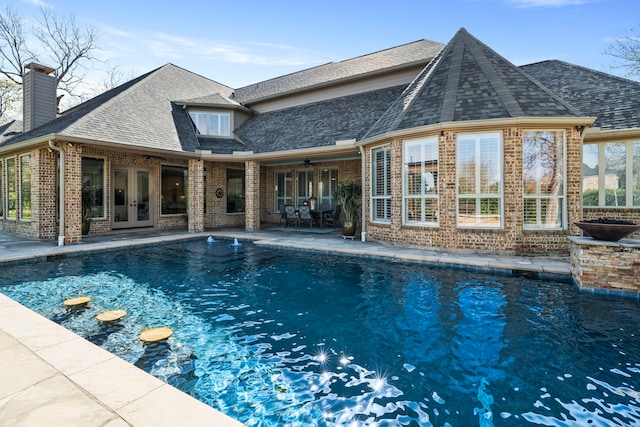 view of swimming pool featuring ceiling fan, french doors, and a patio