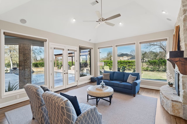 living room with ceiling fan, light hardwood / wood-style floors, french doors, and vaulted ceiling