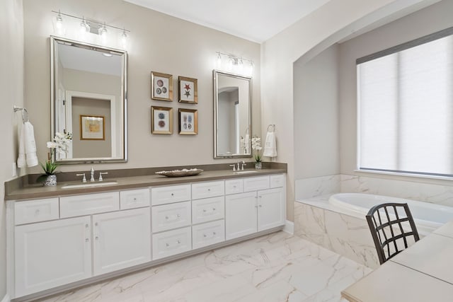 bathroom featuring tiled bath and vanity