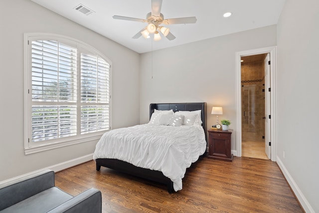 bedroom with ceiling fan, ensuite bathroom, and dark hardwood / wood-style flooring