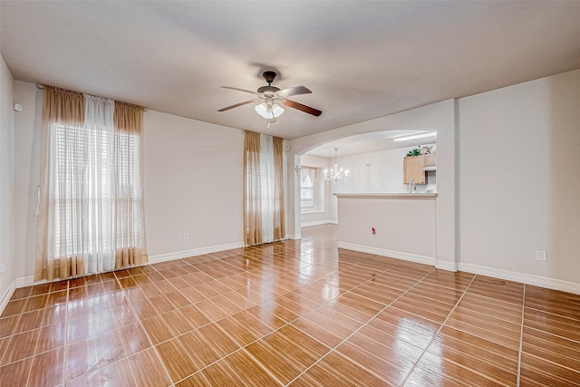 unfurnished living room with ceiling fan with notable chandelier