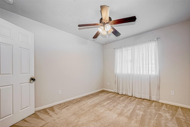 empty room featuring ceiling fan and light colored carpet