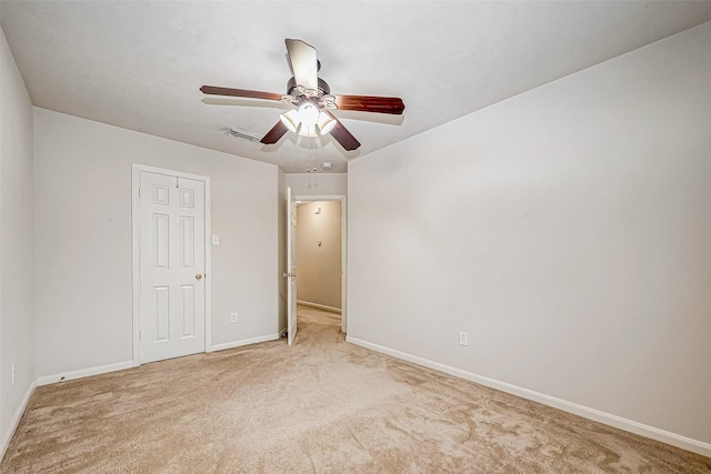 unfurnished bedroom featuring ceiling fan, light carpet, and a closet