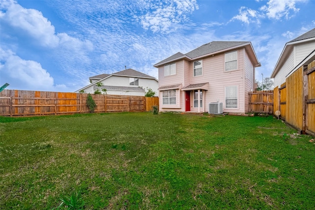 back of house with a yard and central AC unit