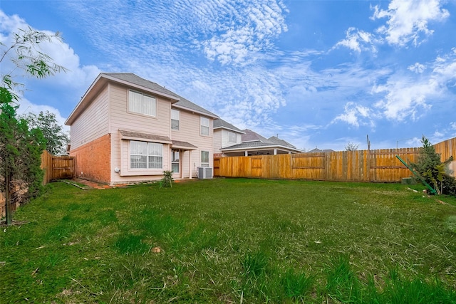 rear view of house featuring central AC and a lawn