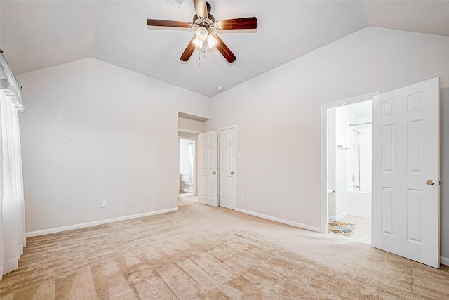 unfurnished bedroom featuring light carpet, ceiling fan, lofted ceiling, and connected bathroom