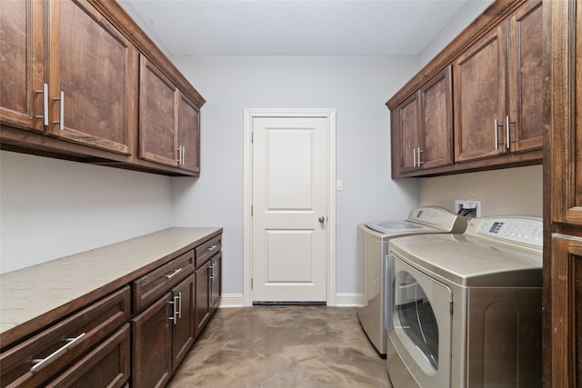 clothes washing area featuring washer and dryer and cabinets