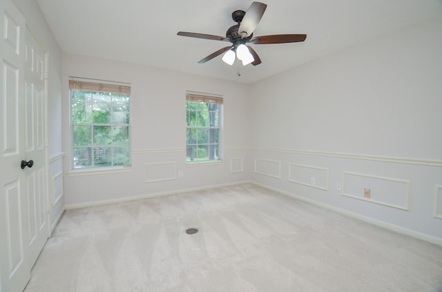 spare room with ceiling fan and light colored carpet