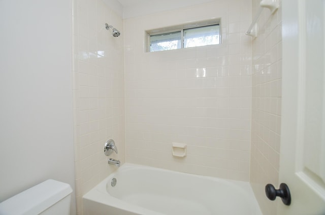 bathroom featuring toilet and tiled shower / bath combo