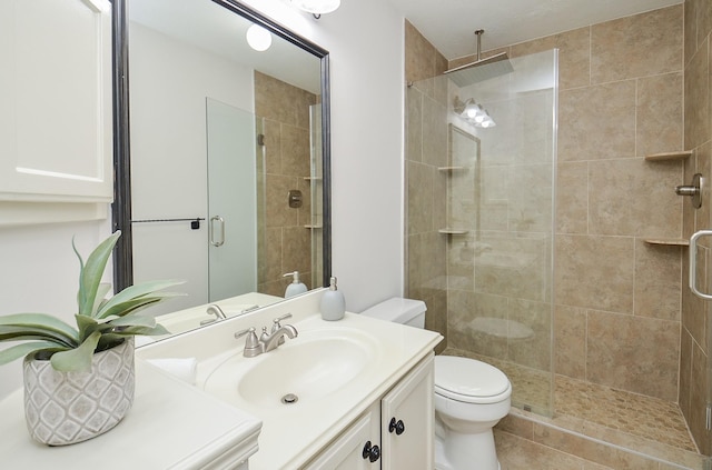 bathroom with vanity, toilet, and a shower with door