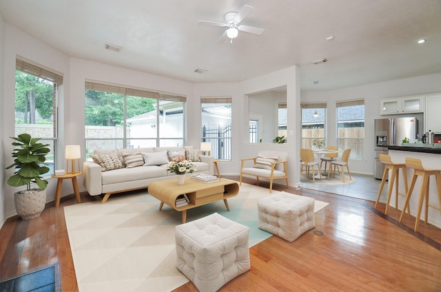 living room with ceiling fan, a healthy amount of sunlight, and light wood-type flooring