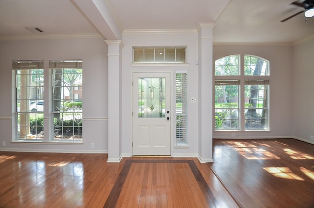 foyer entrance with ornate columns, ornamental molding, and ceiling fan