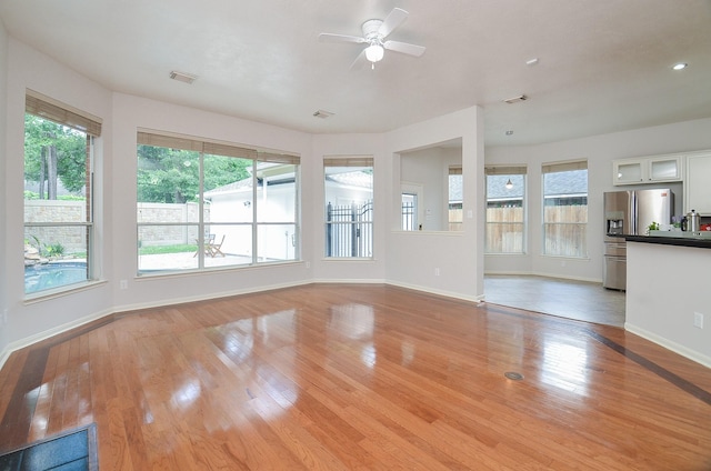 unfurnished living room with ceiling fan and light hardwood / wood-style floors