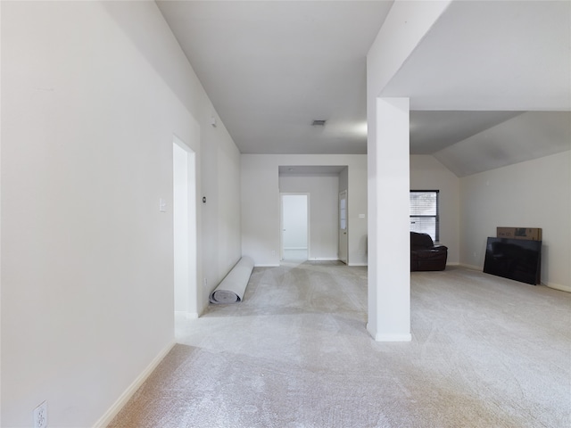 interior space featuring lofted ceiling and light carpet