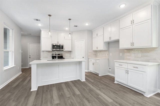 kitchen with decorative light fixtures, white cabinets, appliances with stainless steel finishes, and sink