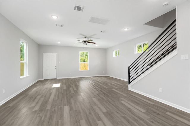 unfurnished living room featuring ceiling fan and dark wood-type flooring