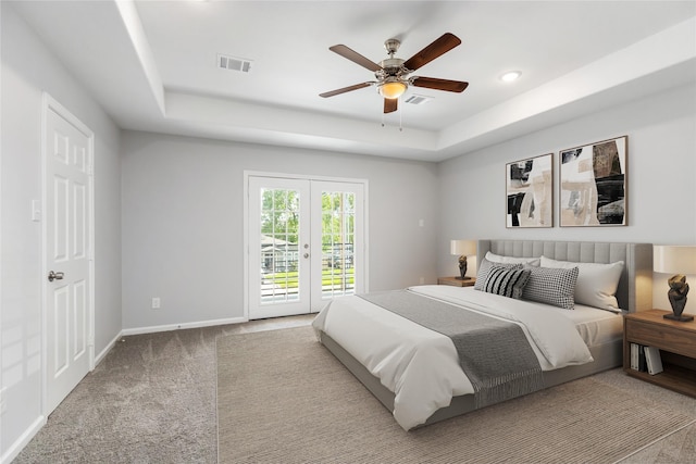 bedroom with a raised ceiling, access to outside, french doors, and ceiling fan