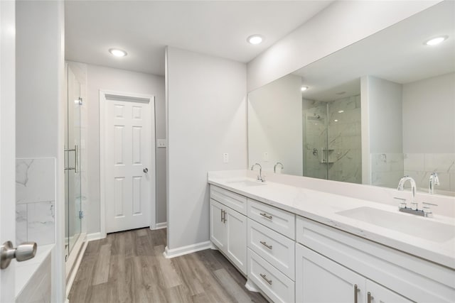 bathroom with vanity, hardwood / wood-style floors, and a shower with door