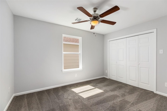 unfurnished bedroom featuring ceiling fan, a closet, and dark carpet