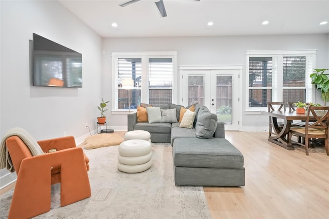 living room with ceiling fan, french doors, a wealth of natural light, and light wood-type flooring