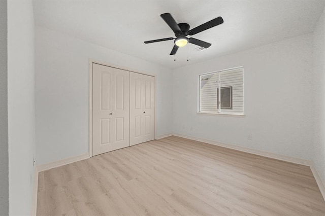 unfurnished bedroom featuring ceiling fan, a closet, and light hardwood / wood-style flooring