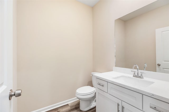 bathroom featuring toilet, hardwood / wood-style floors, and vanity