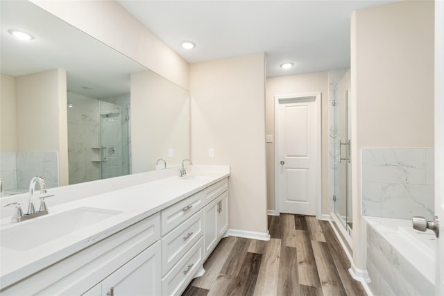 bathroom featuring wood-type flooring, vanity, and separate shower and tub