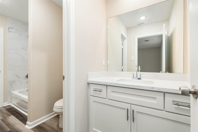 full bathroom featuring toilet, tiled shower / bath combo, hardwood / wood-style flooring, and vanity