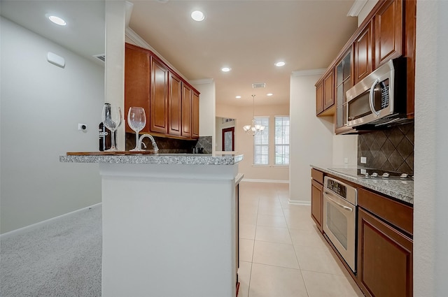 kitchen with stainless steel appliances, backsplash, hanging light fixtures, kitchen peninsula, and a notable chandelier