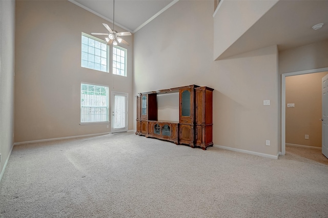 unfurnished living room featuring high vaulted ceiling, light carpet, crown molding, and ceiling fan